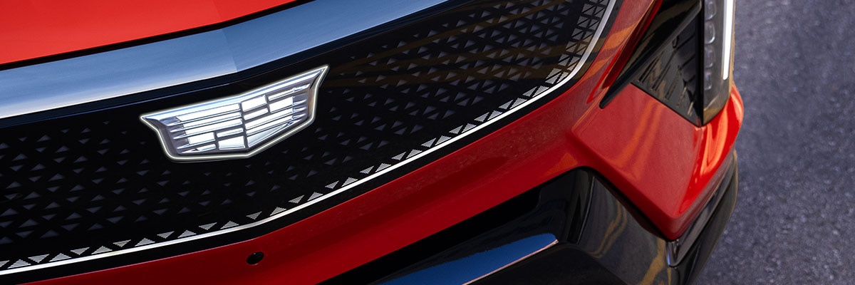 Cadillac OPTIQ 2027 con detalle del emblema en la parrilla frontal